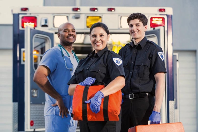 a group of paramedics standing in front of an ambulance