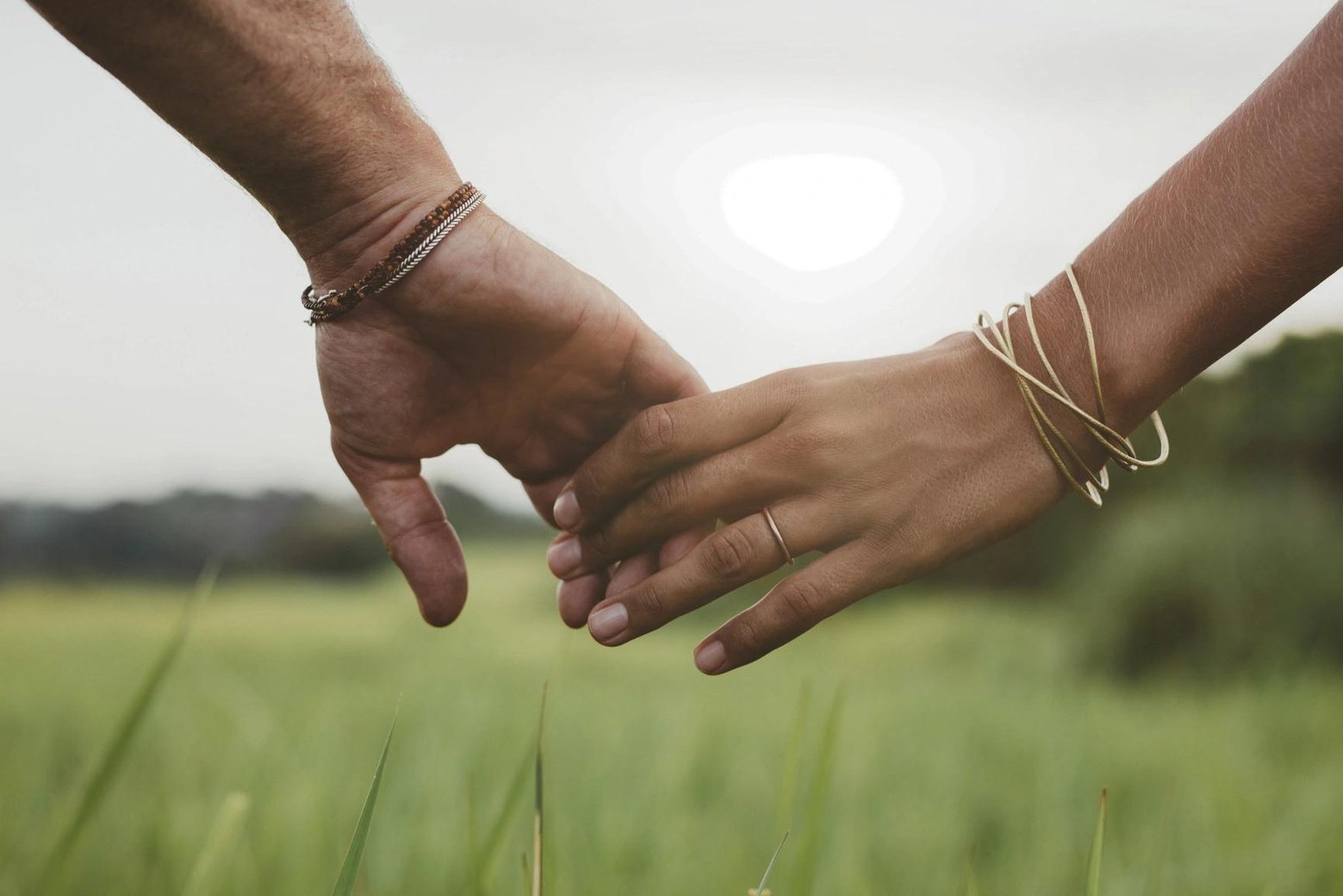 two people holding hands in a field