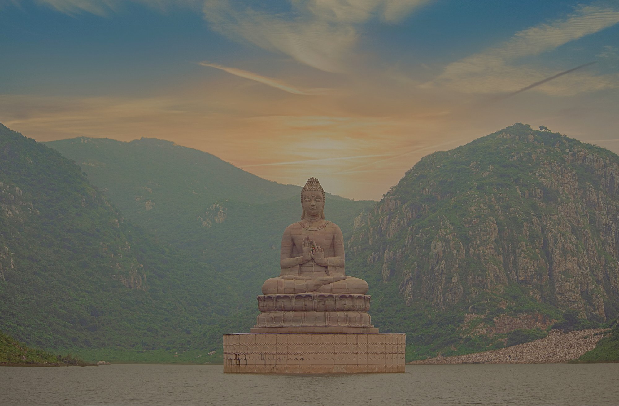 a large buddha statue sits in the middle of a lake